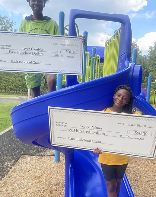 A Boy And  A Girl Holding A Huge Check